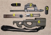 Photo of a disassembled PS90, showing the major component groups: 1. trigger group, 2. barrel and optical sight assembly, 3. butt plate, 4. magazine, 5. bolt carrier and recoil assembly, 6. stock body and trigger.